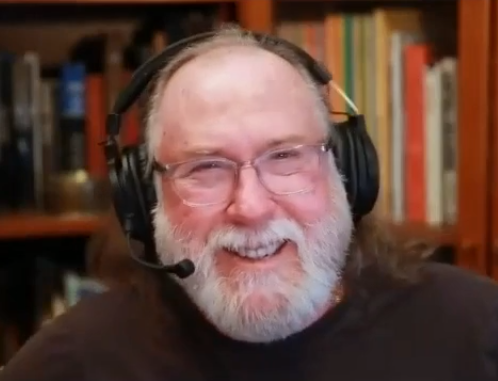 Chip Chapin, a kind-looking bespectacled older man with happy eyes and a nicely-kept beard smiles earnestly into the camera in front of a wall of wooden cabinets enclosing several orderly rows of books. A headset that includes a pair of headphones and a microphone sits atop Chip Chapin's balding head as he speaks about his investing experiences to his interviewer Jordan Thibodeau using an internet video-chat service.